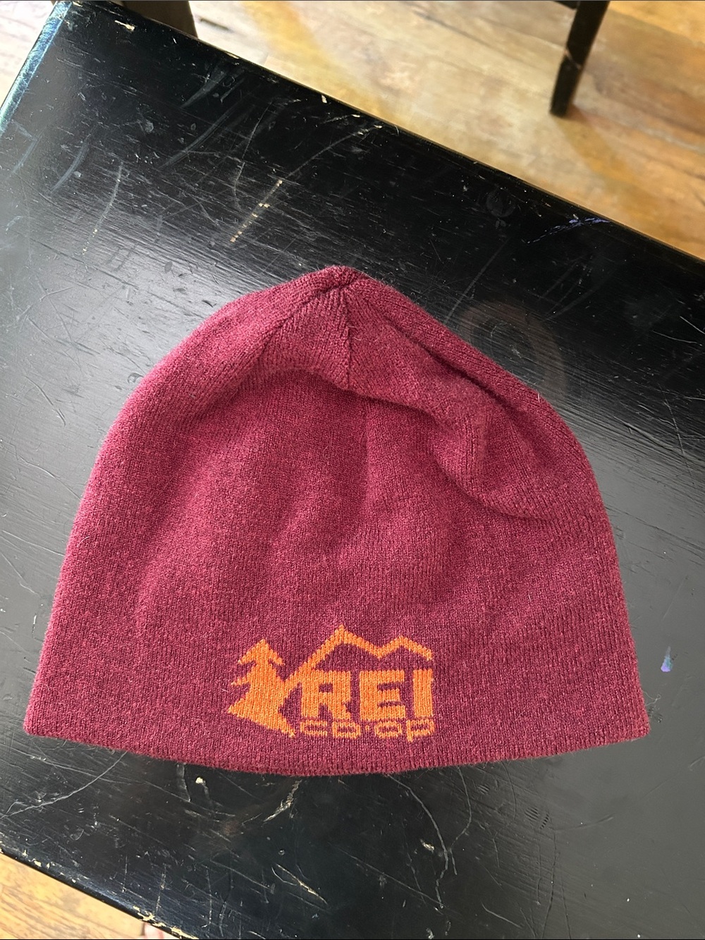 REI Burgundy Beanie with Orange Logo and Orange on the inside.